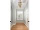 Hallway with hardwood floors, natural light, and decorative chandelier at 24 Waterway Island Dr, Isle of Palms, SC 29451