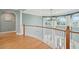 Upstairs hallway with wood floors and trim, bright arched windows, and crisp white walls at 24 Waterway Island Dr, Isle of Palms, SC 29451
