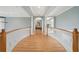 Upstairs hallway featuring hardwood floors, white columns, and detailed trim work at 24 Waterway Island Dr, Isle of Palms, SC 29451