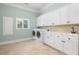 Functional laundry room with washer, dryer, storage cabinets, and sink at 24 Waterway Island Dr, Isle of Palms, SC 29451
