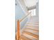 Bright staircase with wood treads, white risers, and natural wood railing, well-lit by a window at 24 Waterway Island Dr, Isle of Palms, SC 29451