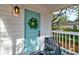 Inviting front porch with a charming blue door, wreath, and a cozy sitting area at 2604 Ferrara Dr, North Charleston, SC 29405