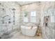 Elegant bathroom featuring a standalone tub, a spacious shower, and beautiful marble tile walls and flooring at 307 Shoals Dr, Mount Pleasant, SC 29464