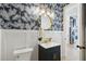 Stylish powder room featuring custom palm wallpaper, modern vanity, and beautiful gold mirror and light fixture at 307 Shoals Dr, Mount Pleasant, SC 29464