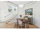 Cozy dining area with hardwood floors, staircase, decorative chandelier, and coastal-themed art at 307 Shoals Dr, Mount Pleasant, SC 29464
