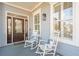 Inviting front porch with rocking chairs, pillows and a stained glass front door at 307 Shoals Dr, Mount Pleasant, SC 29464