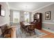 Formal dining room with a large wooden table, rug, and a classic hutch, bathed in natural light at 311 Weston Hall Dr, Summerville, SC 29483