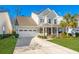 Attractive two-story home with a manicured lawn, attached garage, and a charming front porch perfect for relaxing at 311 Weston Hall Dr, Summerville, SC 29483