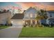 Inviting two-story home at dusk with a green front door, stone accents, and a perfectly manicured lawn at 311 Weston Hall Dr, Summerville, SC 29483