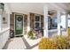Charming front porch with stone accents, rocking chairs, and a decorative wreath on the green front door at 311 Weston Hall Dr, Summerville, SC 29483