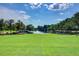 Expansive green space with a central fountain and serene lake view, framed by lush trees and manicured lawns at 311 Weston Hall Dr, Summerville, SC 29483