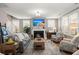 Bright living room with a fireplace, TV, hardwood floors, stairs, and large window for natural light at 311 Weston Hall Dr, Summerville, SC 29483