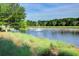 Scenic pond featuring a fountain, bordered by lush grass and mature trees, creating a peaceful waterfront setting at 311 Weston Hall Dr, Summerville, SC 29483