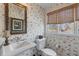 Cozy bathroom with floral wallpaper, traditional fixtures, and a decorative mirror at 3121 Marshgate Dr, Johns Island, SC 29455