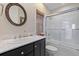 Stylish bathroom boasts a circular mirror, dark vanity with marble countertop, and a shower-tub combo at 3121 Marshgate Dr, Johns Island, SC 29455