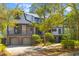 Charming two-story home featuring a brick façade, metal roof, second story porch, and manicured landscaping at 3121 Marshgate Dr, Johns Island, SC 29455