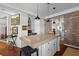 Spacious kitchen island with seating, brick accents and hardwood flooring at 3121 Marshgate Dr, Johns Island, SC 29455