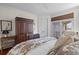Bright main bedroom boasts hardwood floors, a large decorative wardrobe, and access to a balcony with calming views at 3121 Marshgate Dr, Johns Island, SC 29455