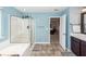 Bathroom showcasing a glass-enclosed shower, soaking tub, tile floors, and doorway to main bedroom at 327 Freeland Way, Moncks Corner, SC 29461