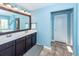 Bathroom showcasing double sinks with dark cabinetry, tile floors, blue walls, and a large mirror at 327 Freeland Way, Moncks Corner, SC 29461