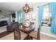 Bright dining area featuring a wooden table, blue curtains, and convenient access to the living room at 327 Freeland Way, Moncks Corner, SC 29461