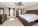 Spacious main bedroom featuring a tray ceiling, ceiling fan, windows with curtains, and dark wood furniture at 327 Freeland Way, Moncks Corner, SC 29461
