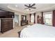 Bright main bedroom with tray ceiling, ceiling fan, large windows, and dark wood furniture at 327 Freeland Way, Moncks Corner, SC 29461