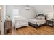 Cozy bedroom showcasing hardwood floors, a crib, and a large window for plenty of natural light at 3858 Sawyers Island Dr, Mount Pleasant, SC 29466