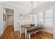 Cozy dining room with hardwood floors and rustic wooden table and benches, illuminated by a stylish chandelier at 3858 Sawyers Island Dr, Mount Pleasant, SC 29466