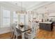 Bright dining area featuring hardwood floors, a modern chandelier, and a view into a white kitchen at 3858 Sawyers Island Dr, Mount Pleasant, SC 29466