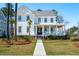 Charming two-story home with a welcoming front porch, lush lawn, and beautifully landscaped yard at 3858 Sawyers Island Dr, Mount Pleasant, SC 29466