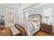 Elegant main bedroom featuring a tray ceiling, hardwood floors, and a seating area with a cushioned bench at 3858 Sawyers Island Dr, Mount Pleasant, SC 29466