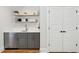 Stylish wet bar with floating shelves, gray cabinets, stainless steel appliances, and a sink at 3858 Sawyers Island Dr, Mount Pleasant, SC 29466