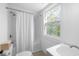 Bathroom features a shower with white subway tile and a bright window at 418 Geddes Ave, Charleston, SC 29407