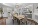 Dining room with hardwood floors that transition to a sunroom and view into a kitchen with a breakfast bar at 418 Geddes Ave, Charleston, SC 29407