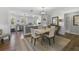 Well-lit dining room features hardwood floors, white wainscoting, and a view into the adjacent kitchen at 418 Geddes Ave, Charleston, SC 29407