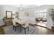 Bright dining room featuring hardwood floors, neutral colors, wainscotting, and a doorway to an adjacent living room at 418 Geddes Ave, Charleston, SC 29407