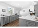 Bright kitchen boasts stainless appliances, gray cabinets, quartz counters and hardwood floors at 418 Geddes Ave, Charleston, SC 29407