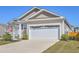 Tan one-story home featuring an attached two-car garage and manicured front lawn at 430 Eastern Pine Dr, Summerville, SC 29486