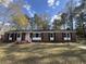 Charming brick home featuring black shutters, a manicured lawn, and mature trees at 431 Otis Rd, Walterboro, SC 29488