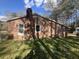View of the rear of a brick house with green grass and large shade trees at 431 Otis Rd, Walterboro, SC 29488