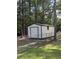 White storage shed in the backyard with a roll-up door and a fenced perimeter at 431 Otis Rd, Walterboro, SC 29488