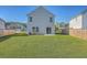 View of the large, grassy backyard with a fence, patio, air conditioning unit, and sliding glass door at 436 Thoroughbred Dr, Moncks Corner, SC 29461