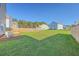 Spacious back yard surrounded by wood fence, lush lawn, blue sky, and mature trees at 436 Thoroughbred Dr, Moncks Corner, SC 29461