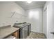 Modern laundry room with full size washer and dryer, utility sink, white walls and neutral flooring at 436 Thoroughbred Dr, Moncks Corner, SC 29461