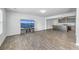 Open-concept living room featuring gray wood floors and a large TV with bridge scenery at 436 Thoroughbred Dr, Moncks Corner, SC 29461