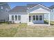 Back view of a house with white siding, a covered patio, and a well-maintained lawn and landscaping at 444 Parish Farm Dr, Summerville, SC 29486