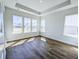 Bright bedroom featuring a tray ceiling, hardwood floors, and ample natural light from multiple windows at 444 Parish Farm Dr, Summerville, SC 29486