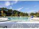 Spacious community pool with lounge chairs and umbrellas surrounded by green trees and blue sky at 444 Parish Farm Dr, Summerville, SC 29486