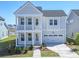 Charming two-story home with a welcoming front porch and a two-car garage and a small landscaped yard at 444 Parish Farm Dr, Summerville, SC 29486